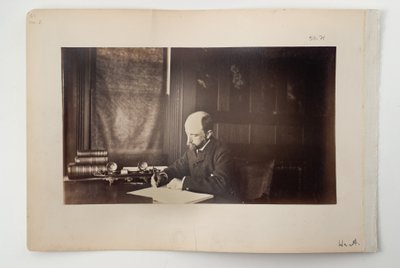 Henry Adams zittend aan een bureau, 1883 door American Photographer